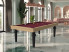 billard Castel BI en chêne nature x2 avec pieds noir laqué et tapis wine, salon pastel élégant avec statues, sol en marbre