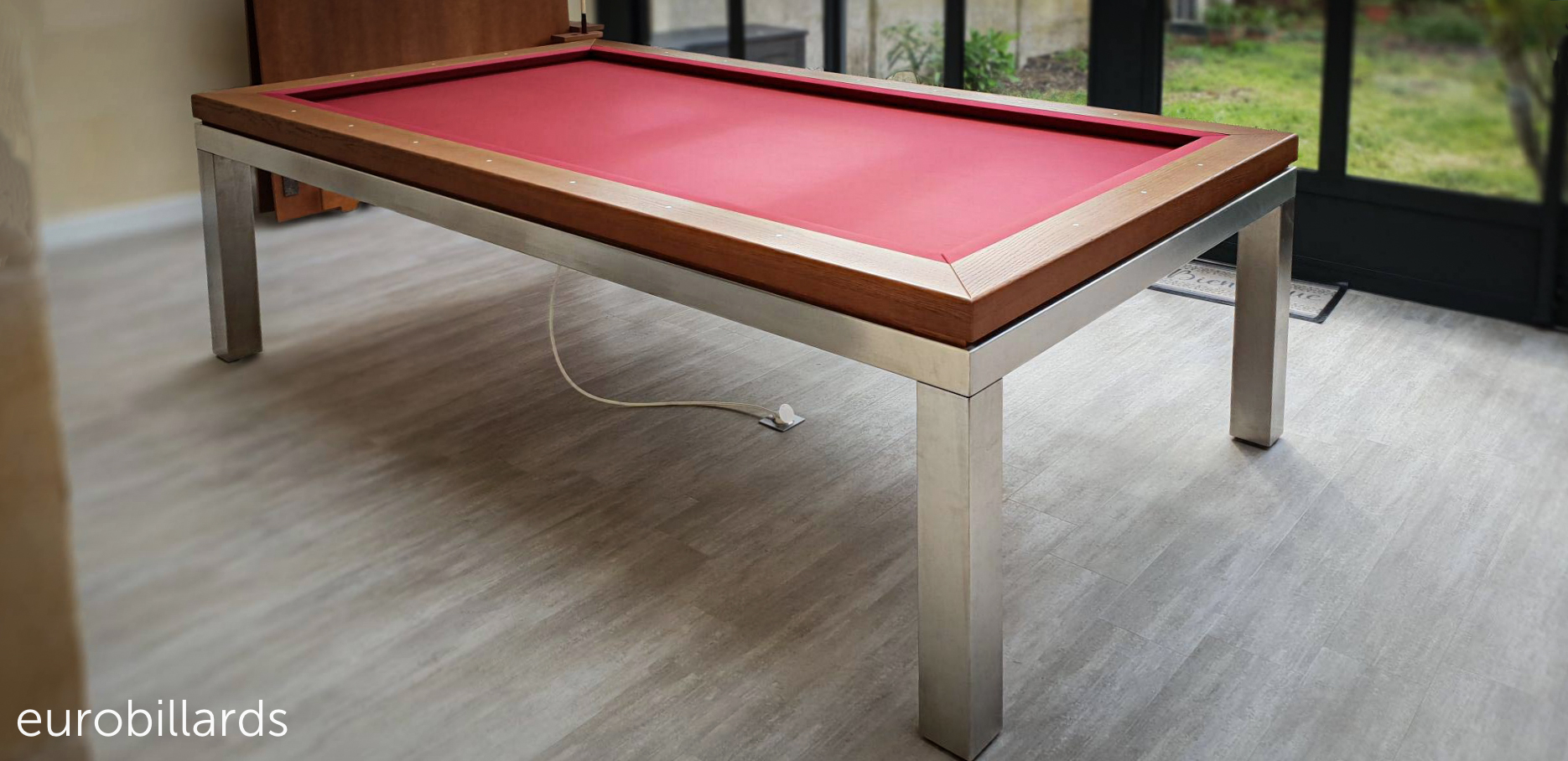 Billard français avec chauffage thermostatique intégré, modèle NEW-TENDANCE-T en finition chêne l802 sur piétement inox monté d'un tapis de jeu rouge, fabriqué par la marque de billard français Eurobillards.
