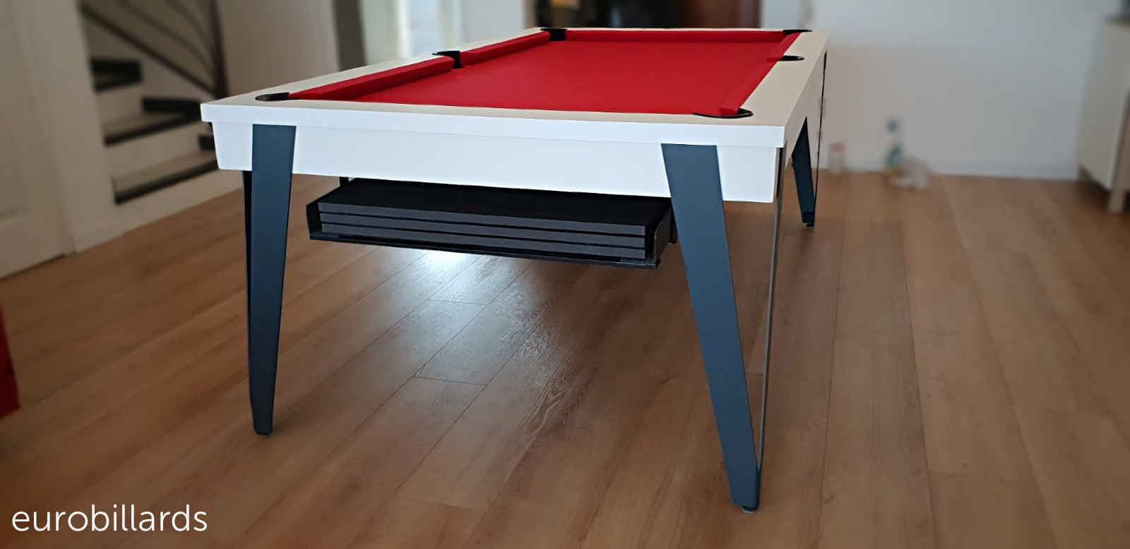 Pendant les parties de jeu, la nacelle escamotable loge soigneusement les 3 éléments du plateau ST nano noir en accord avec le piètement métallique de la table transformable en billard Pendant les parties de jeu, la nacelle escamotable loge soigneusement les 3 éléments du plateau ST nano noir en accord avec le piètement métallique de la table transformable en billard