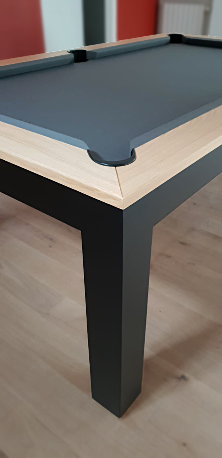 vue de détail sur l'angle du pétement du billard Tendance d'Eurobillards en finition chêne nat 2x sur pieds noirs avec tissu gris ardoise vue de détail sur l'angle du pétement du billard Tendance d'Eurobillards en finition chêne nat 2x sur pieds noirs avec tissu gris ardoise