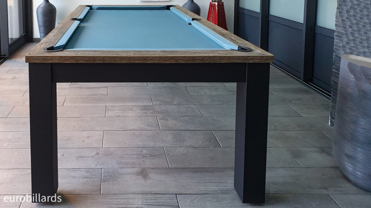 La finition chêne vintage du cadre de billard autour du tissu bleu poudre évoque fortement la nature érigée sur les quatre pieds en parallélépipède rectangle nano noir robustes pour assoir la sérénité de cette salle zen où chaque objet fait écho à l'autre en harmonie maitrisée.