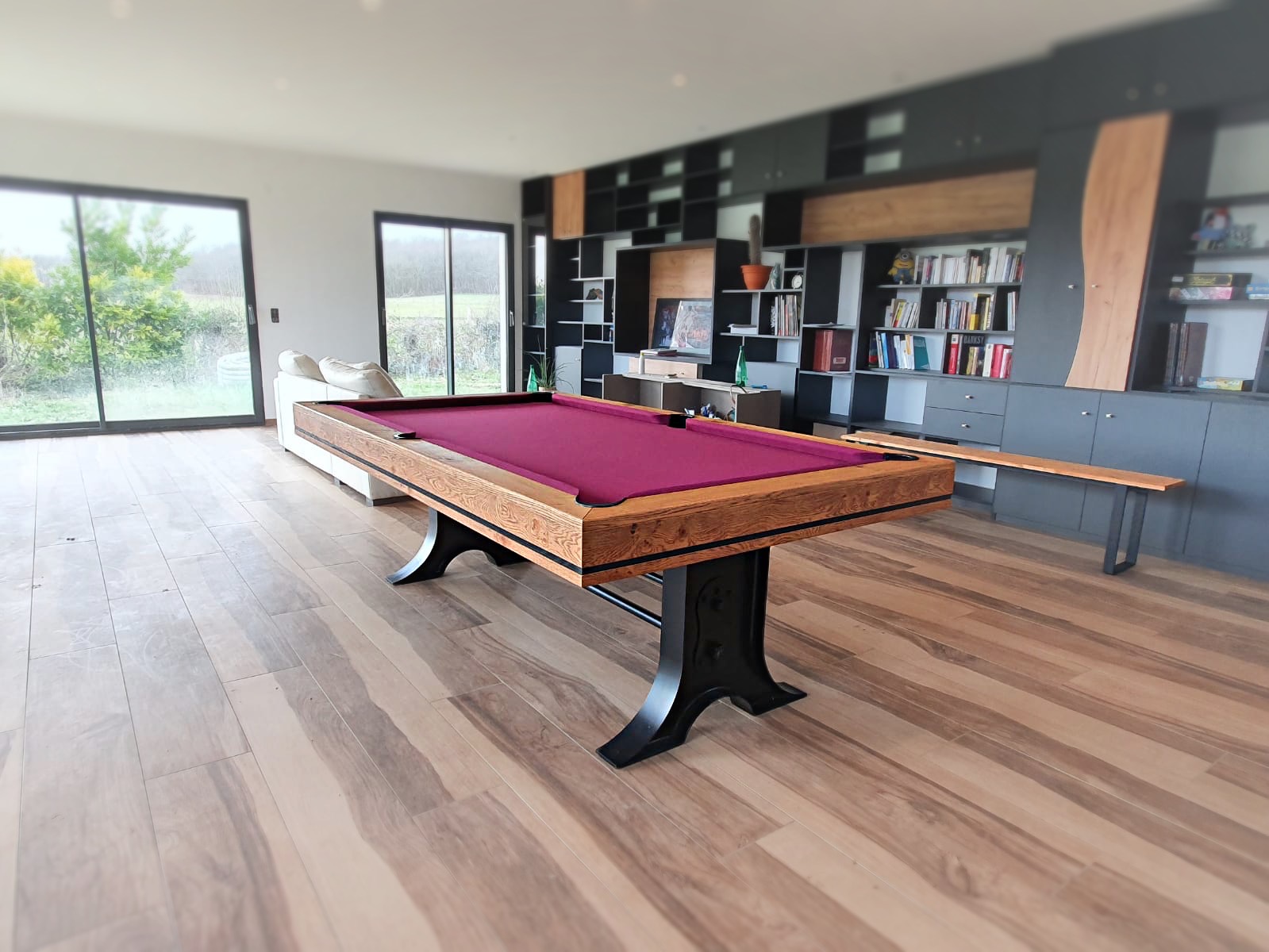 Billard ATELIER de style industriel avec piétement métal noir pour une finition chêne brossé huilé orné d'un fin liseré noir. Le tapis de jeu wine donné la touche enjoué à la pièce une fois la table transformé en billard.