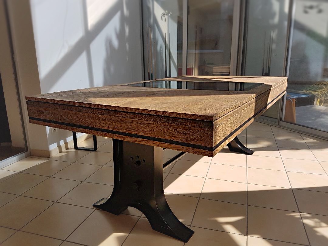 Le tapis de jeu gris ardoise se marie noblement avec l'aspect industriel de ce billard ATELIER bicolore chêne brossé huilé sur pieds tulipe en métal noir.