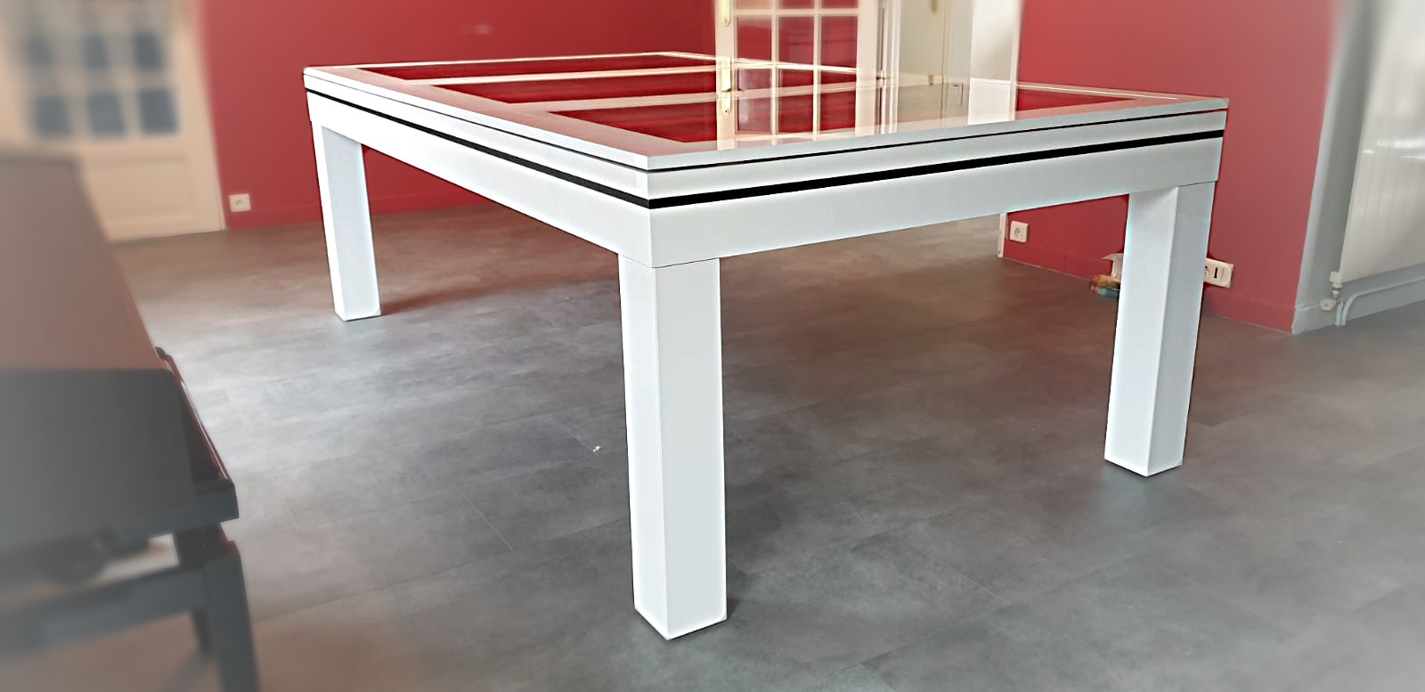 Billard NOVEA transformable en table design de finition blanc brillant avec plateau verre en 3 parties encadrées de blanc et son joli liseré noir.