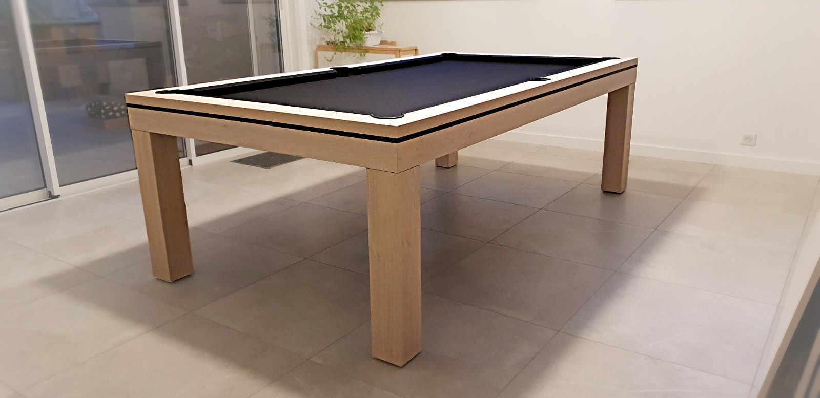 Ce billard NOVEA chêne alpin blanc avec tissu noir se transforme aisément en table par la pose d'un plateau en deux parties.